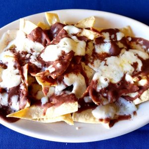 Nachos con queso y frijoles crispy tortillas,refried beans ,melted cheese